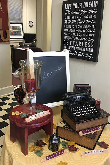 Decorative display for English and Modern Languages open house event. Scrabble trays spell out the words "English", "Spanish", "French", and "Chinese". A blackboard behind the display says "Welcome".